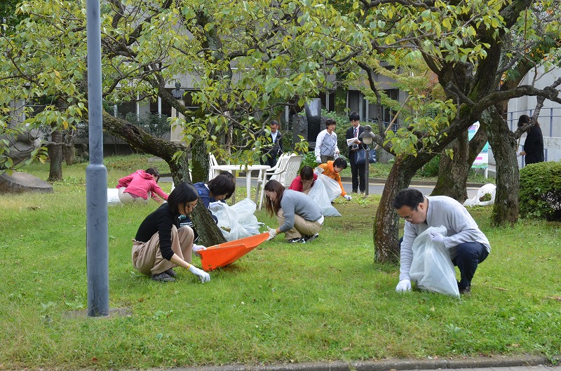 教職員らと落ち葉を拾う澤学長